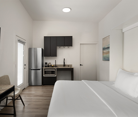 a room with a bed and a refrigerator