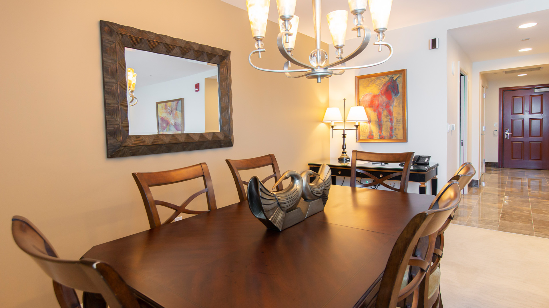 a dining room table with chairs and a mirror