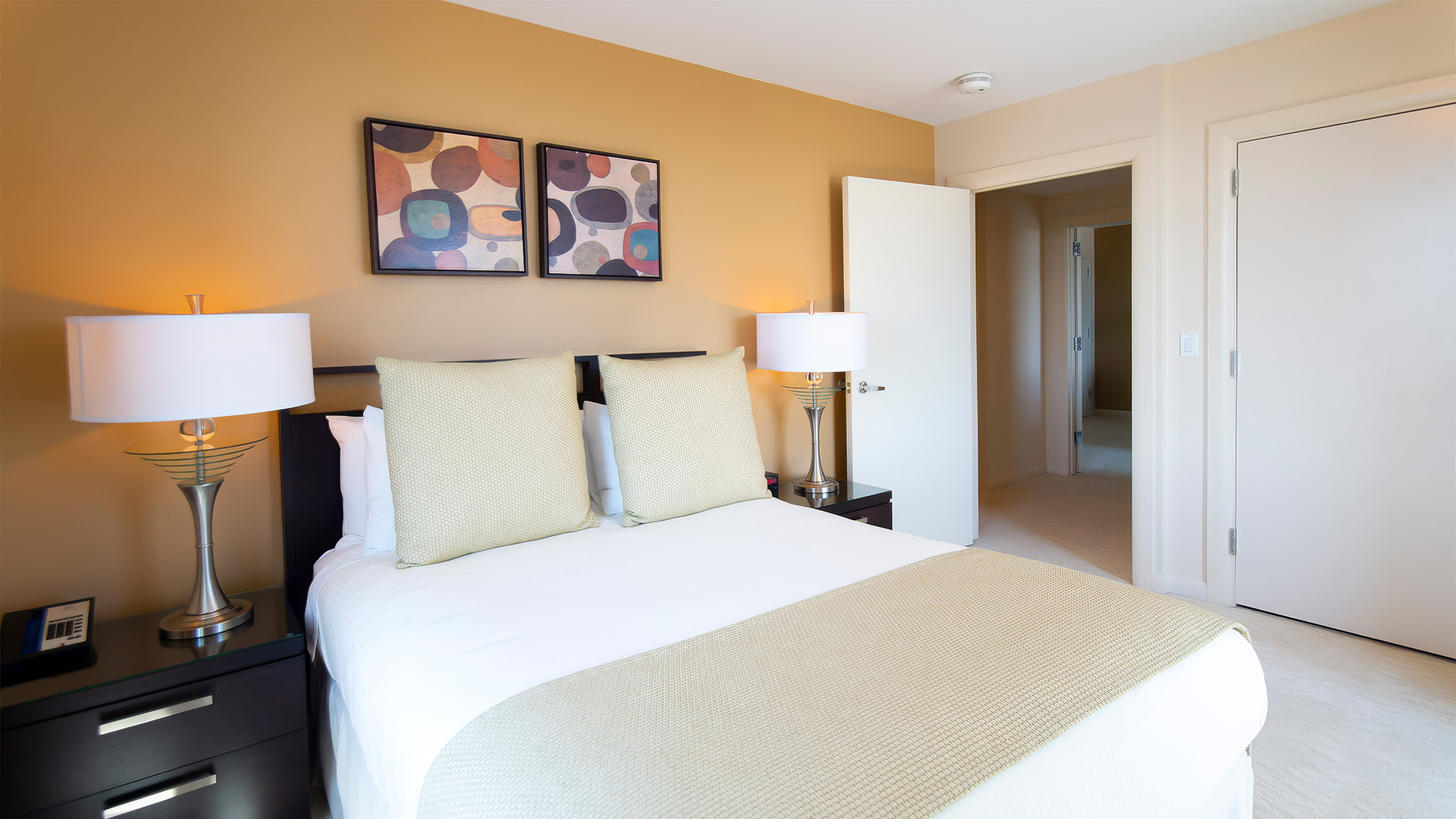 a bed with pillows and a lamp in a room
