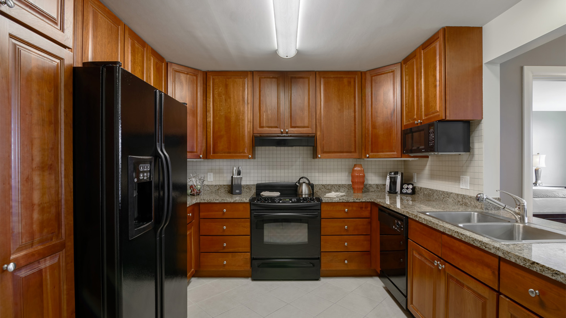 a kitchen with wooden cabinets and black appliances