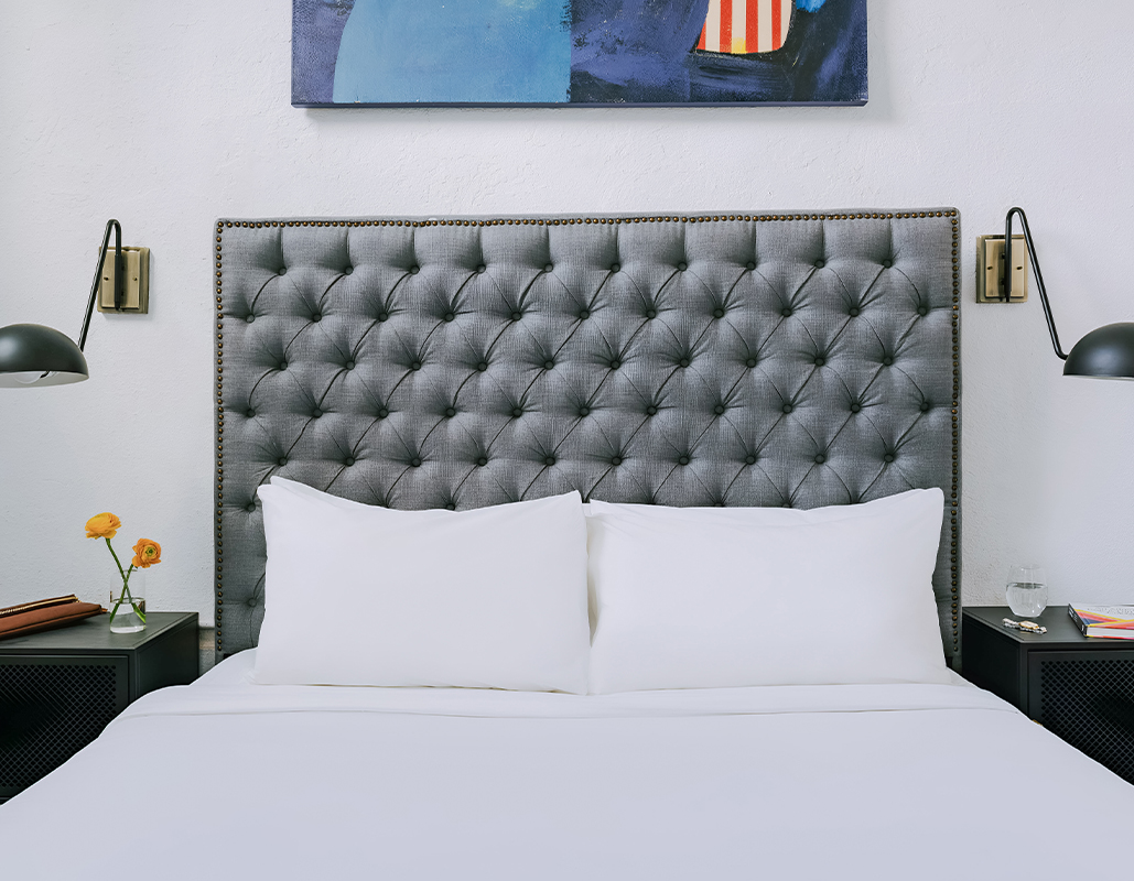a bed with a headboard and a painting above it