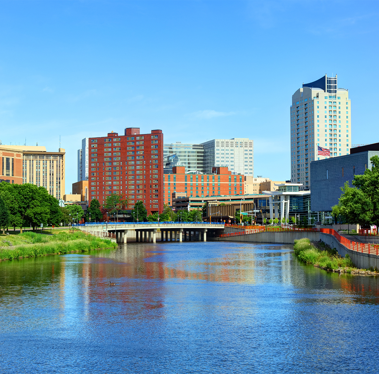 a river with a bridge and buildings in the background