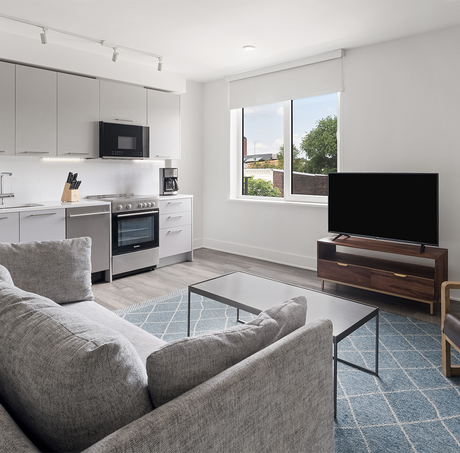 a living room with a couch and kitchen