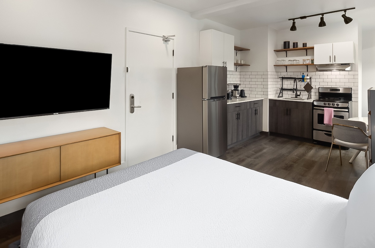 a room with a tv and kitchen