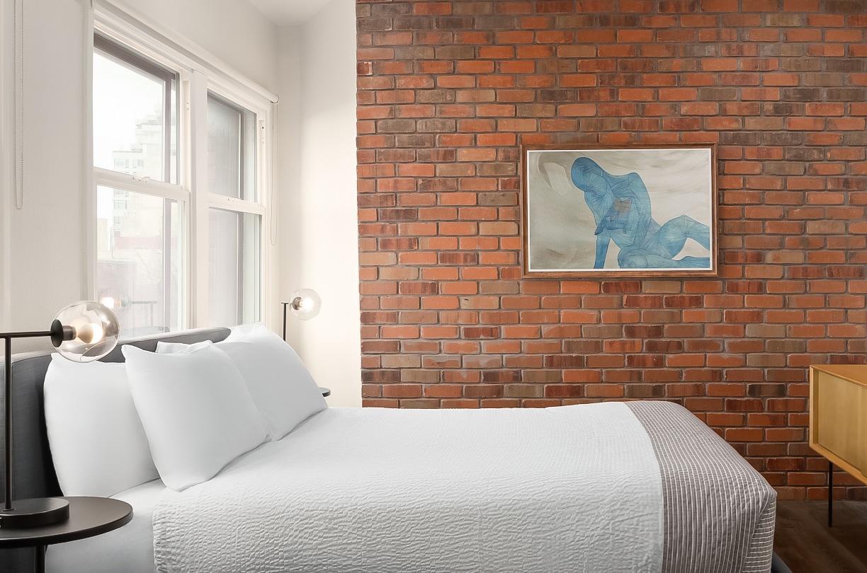 a bed with a painting on the wall
