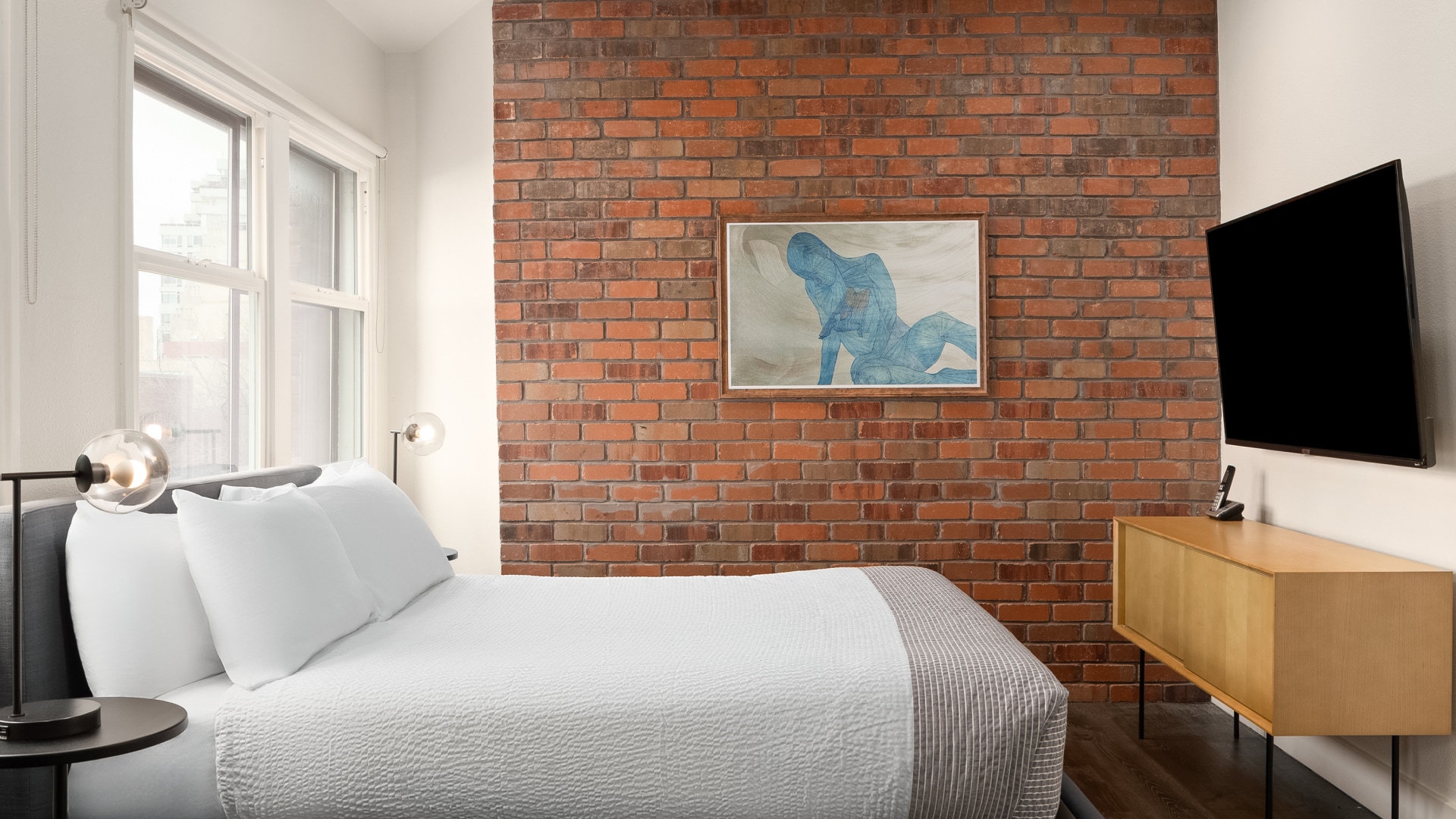 a bed in a room with a brick wall