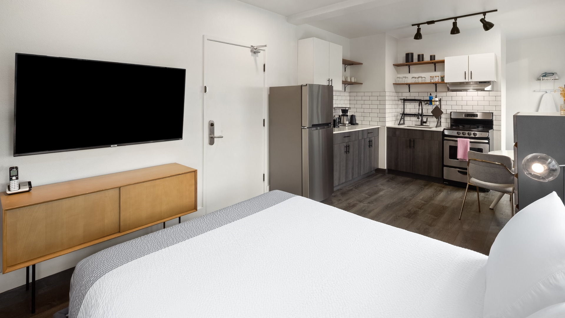 a room with a tv and kitchen
