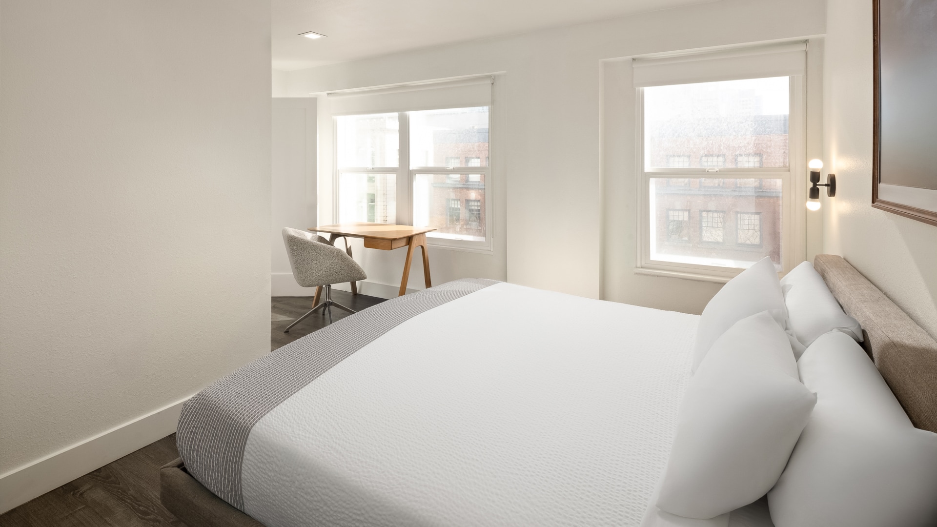 a bed with a desk and windows