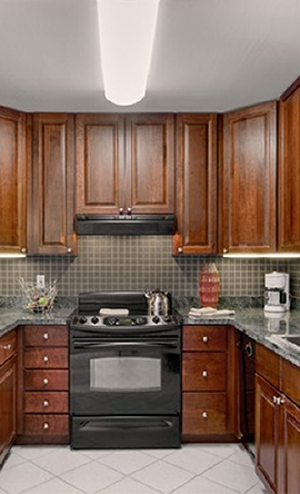 a kitchen with dark wood cabinets and a black stove