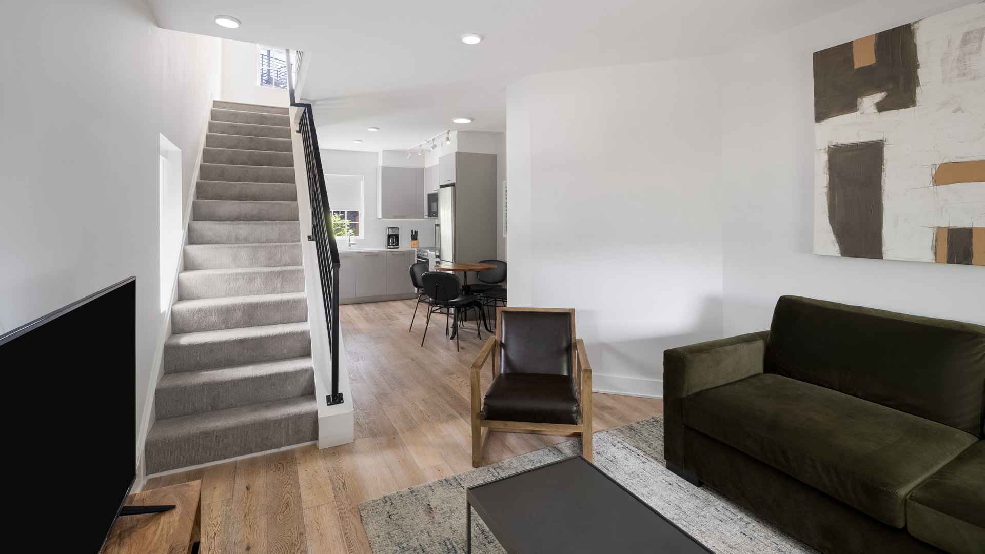 a living room with stairs and couches