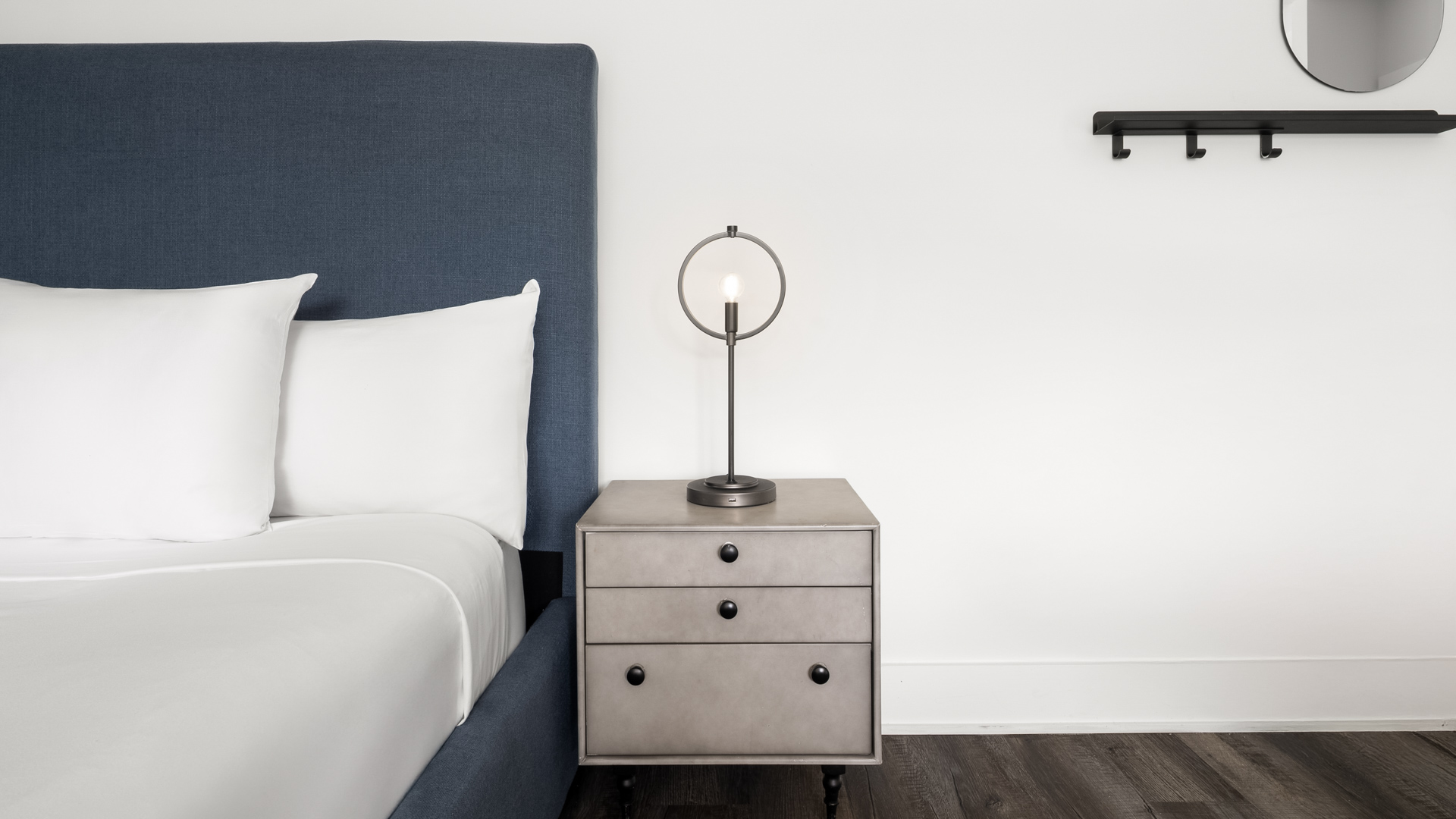 a lamp on a nightstand next to a bed