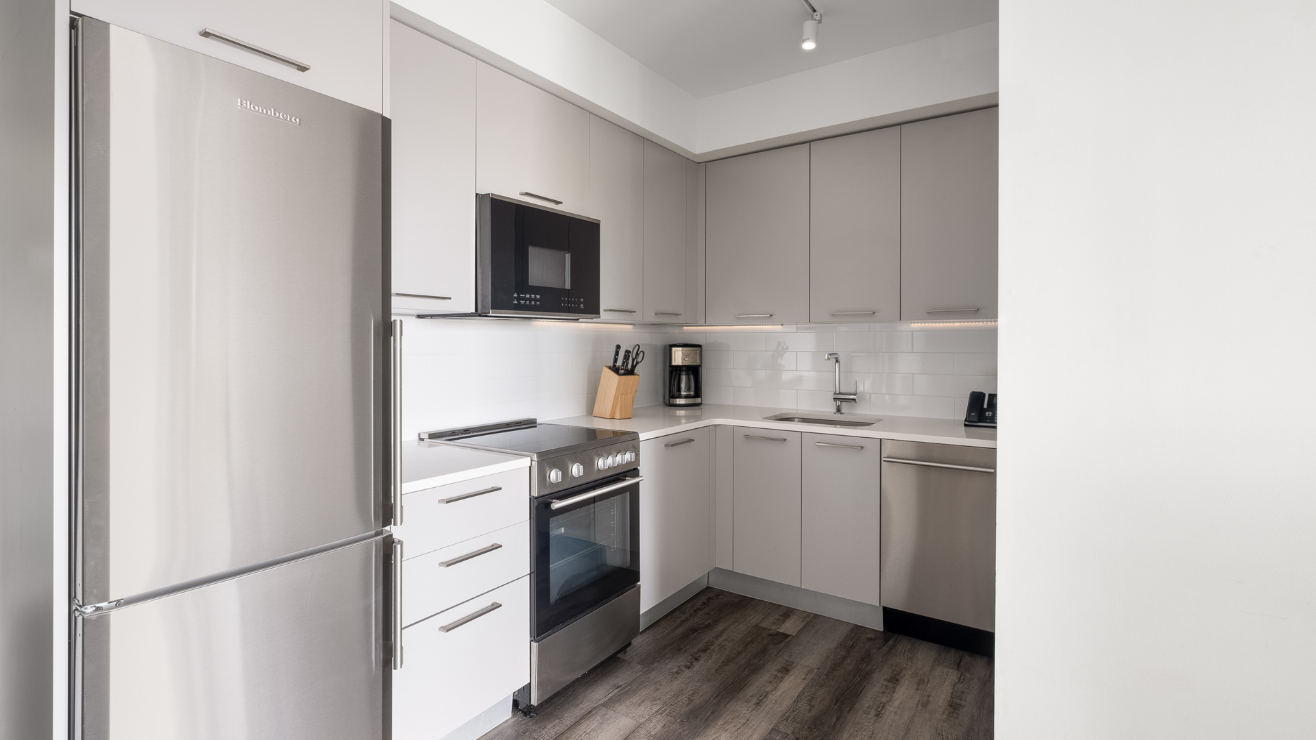 a kitchen with white cabinets and a wood floor