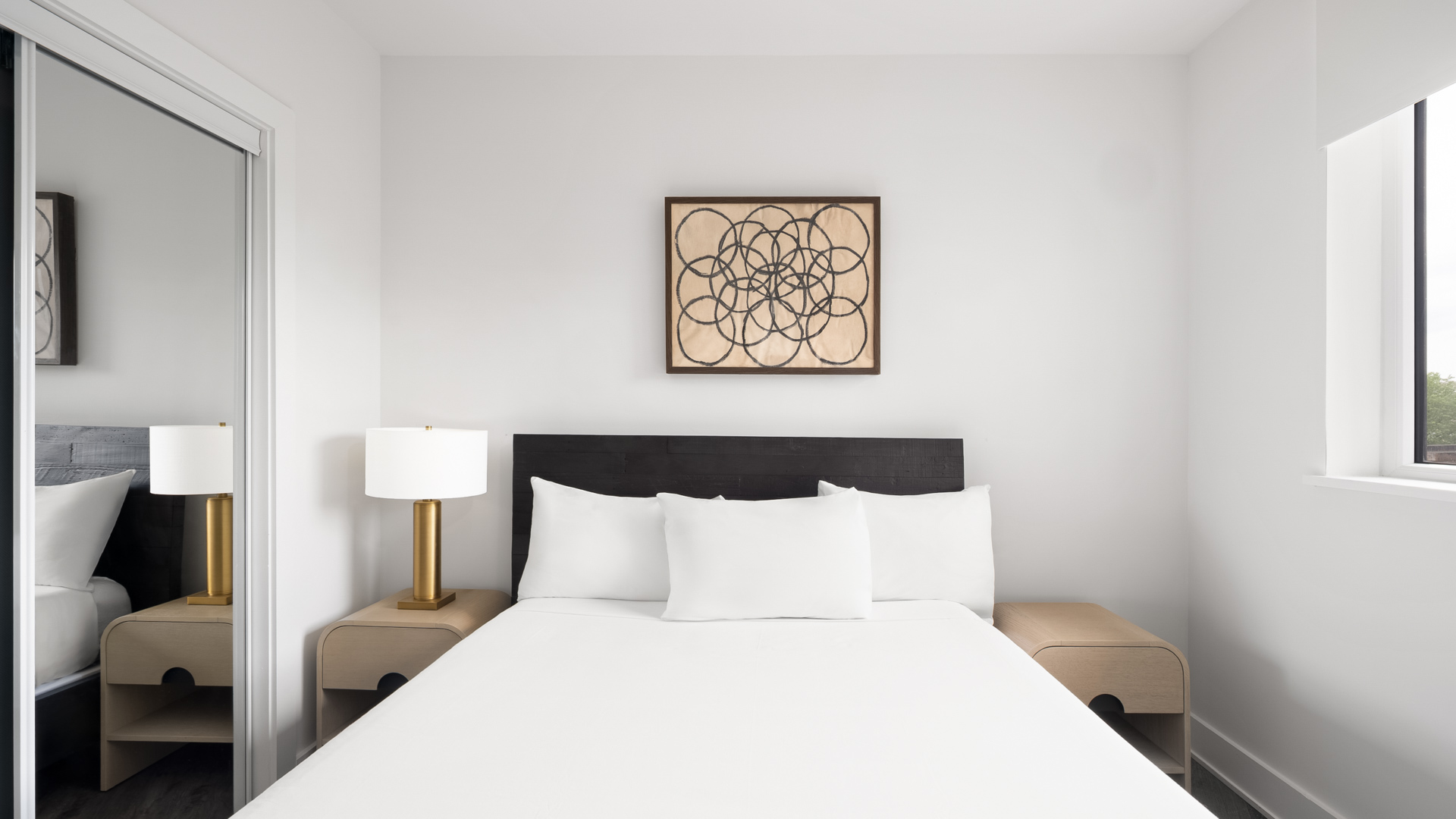 a bed with white sheets and a lamp on a nightstand