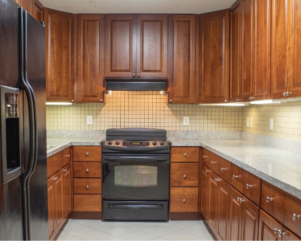 a kitchen with wooden cabinets and black stove