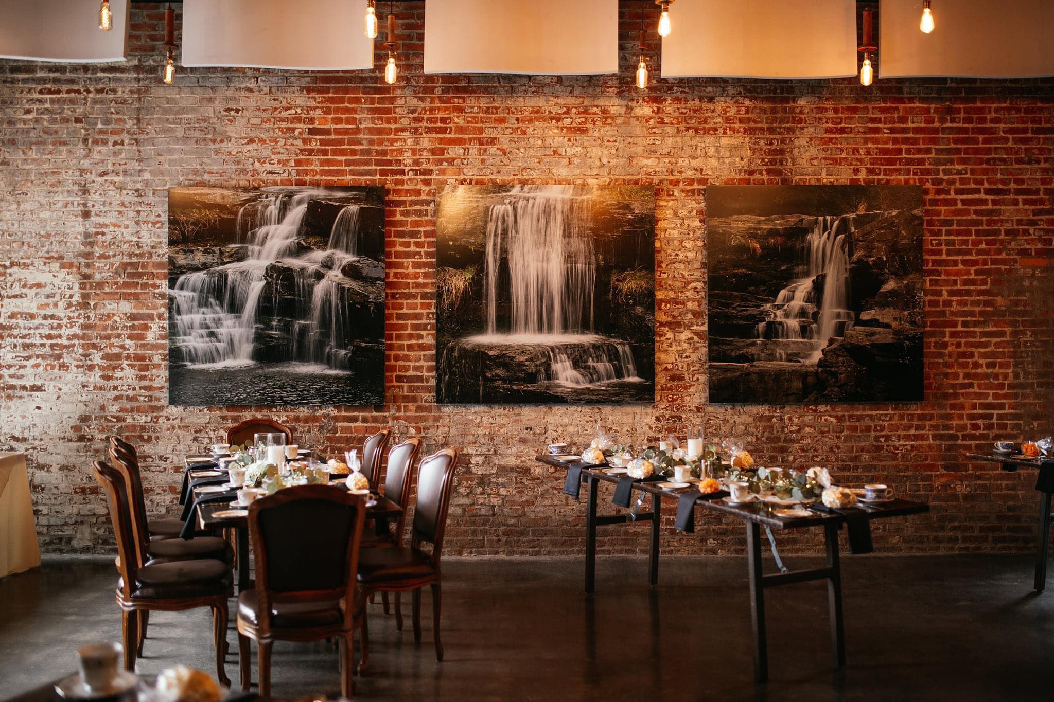 a room with a table and chairs and a waterfall on the wall