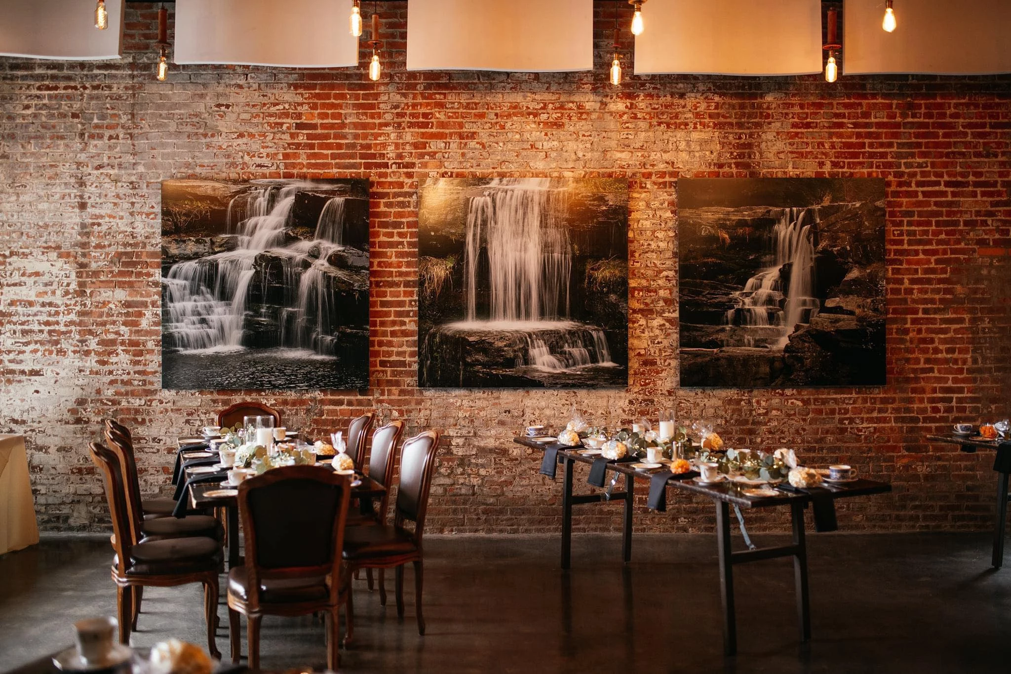 a room with a table and chairs and a waterfall on the wall