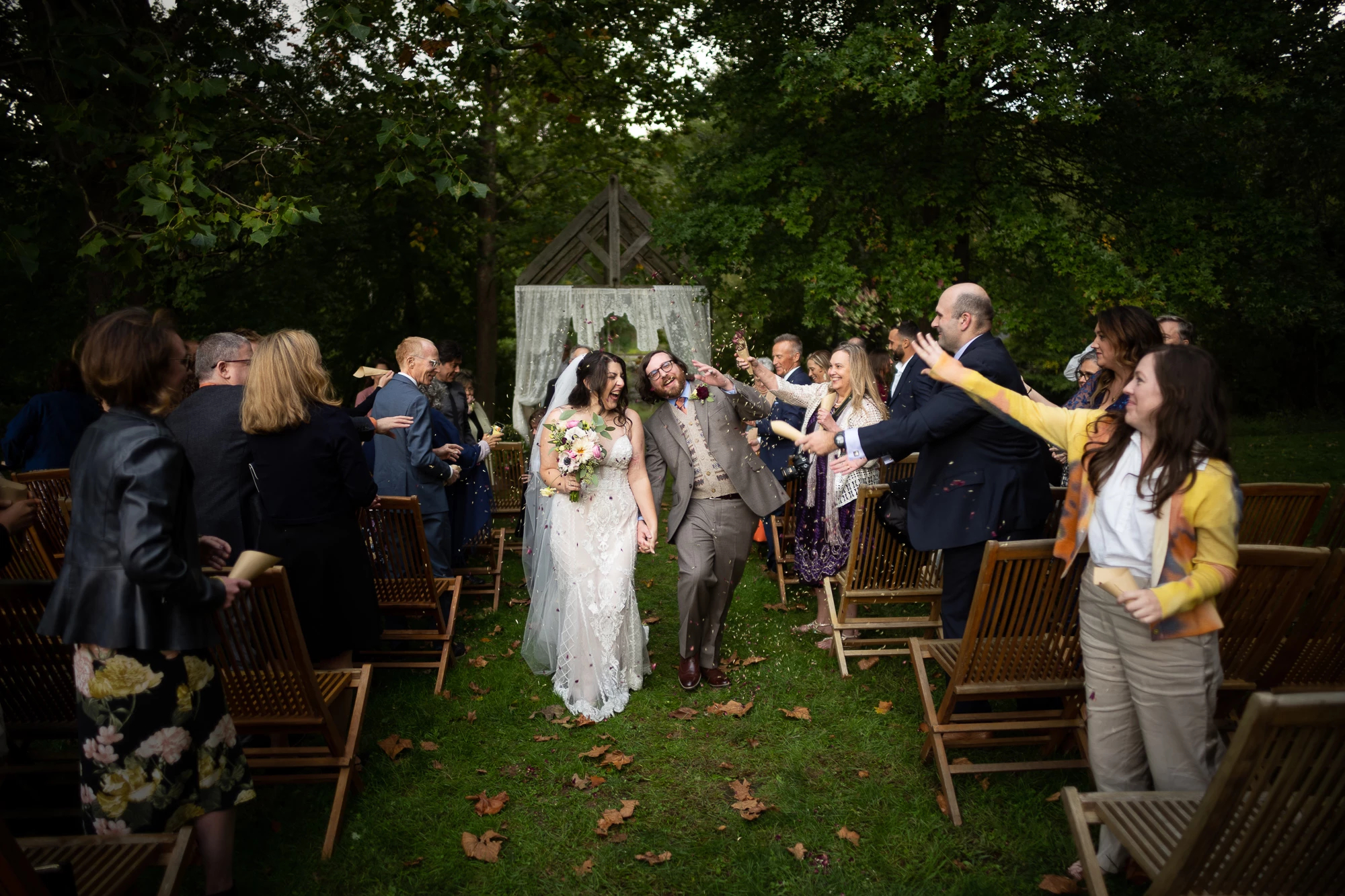 a man and woman walking down a lawn with people around them