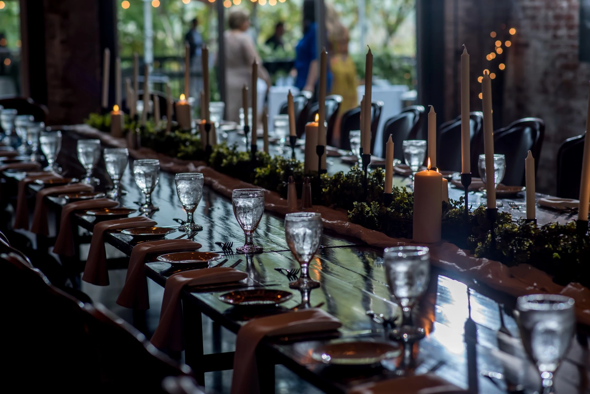 a long table with wine glasses and candles