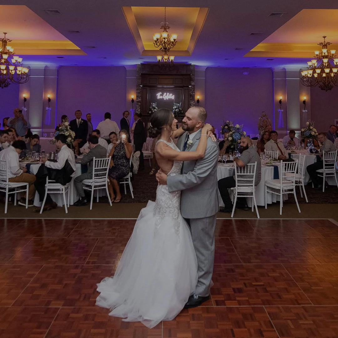 a man and woman dancing in a room with tables and chairs
