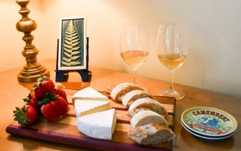 a cheese and strawberries on a cutting board
