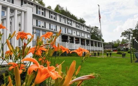 a lawn with orange flowers and a flag in front of a building