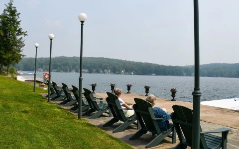 a group of people sitting in chairs by a lake