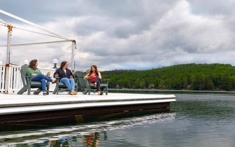 a group of women sitting on chairs on a dock by a lake