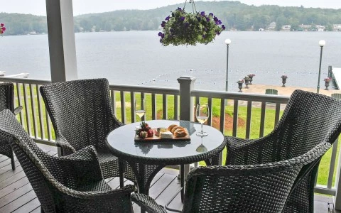 a table and chairs on a porch overlooking a lake