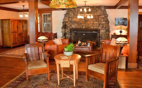 a living room with a fireplace and chairs