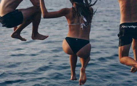 a woman in a garment jumping into the water