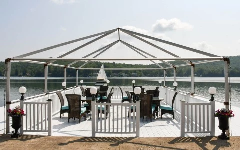 a white deck with a white fence and chairs on it