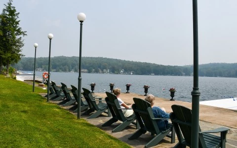 a group of people sitting in chairs by a lake