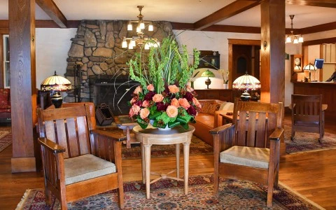 a room with a table with chairs and a vase of flowers