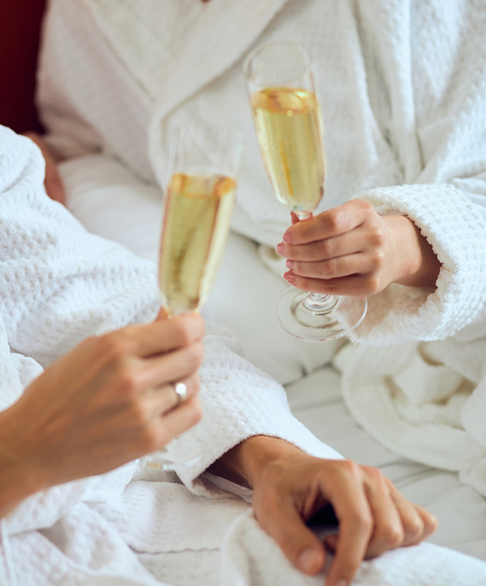 a couple of people in white robes holding champagne glasses
