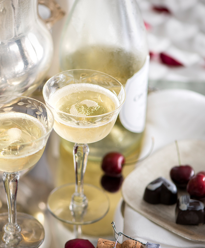 a glass of champagne next to a bottle of chocolate