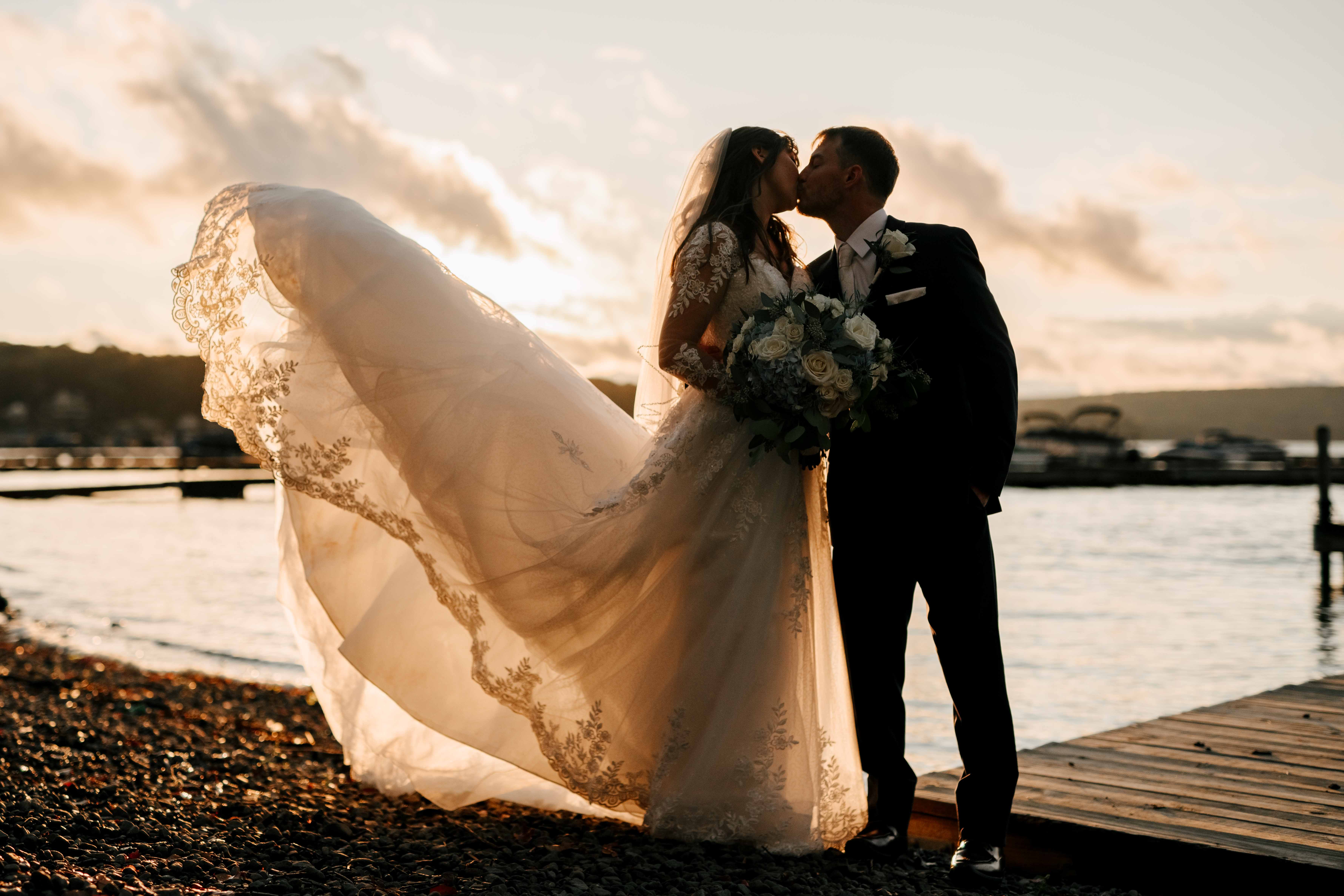 a man and woman kissing on a dock