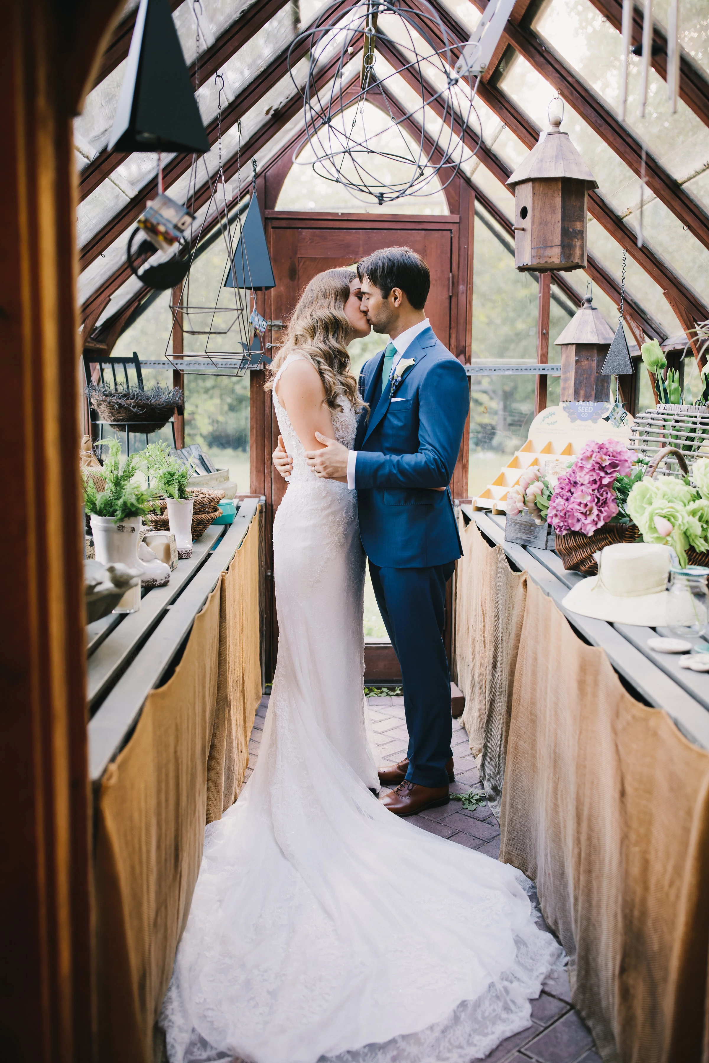 a man and woman kissing in a greenhouse