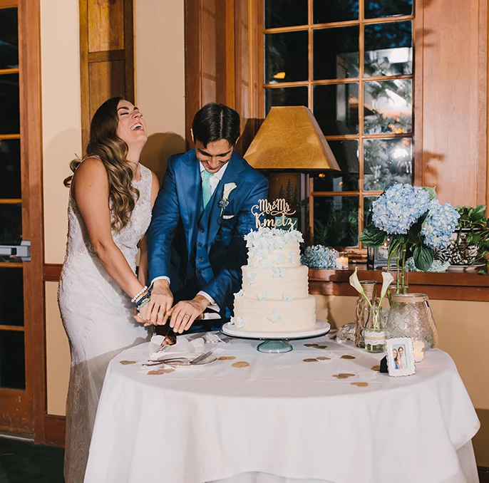 a man and woman cutting a wedding cake