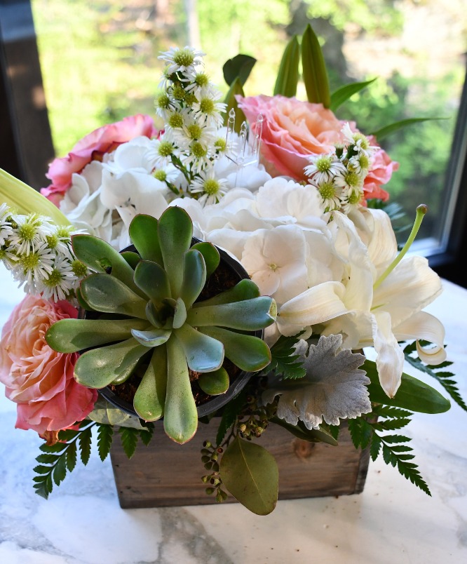 a flower arrangement in a wooden box