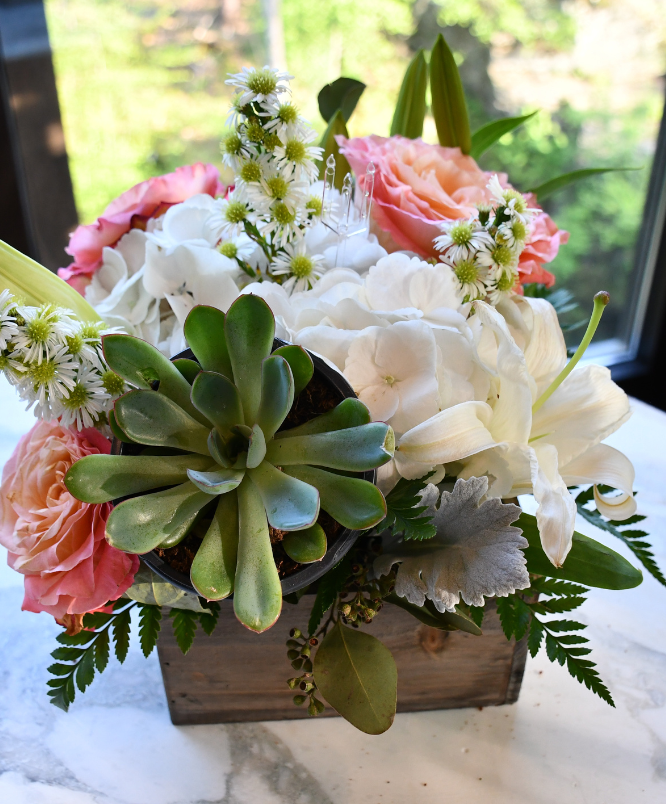 a flower arrangement in a wooden box