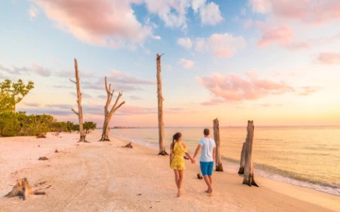 couple walking on beach at sunset
