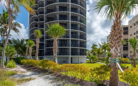 a building with palm trees and grass