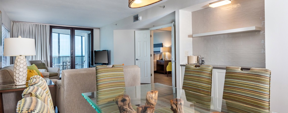 a room with a glass table and chairs