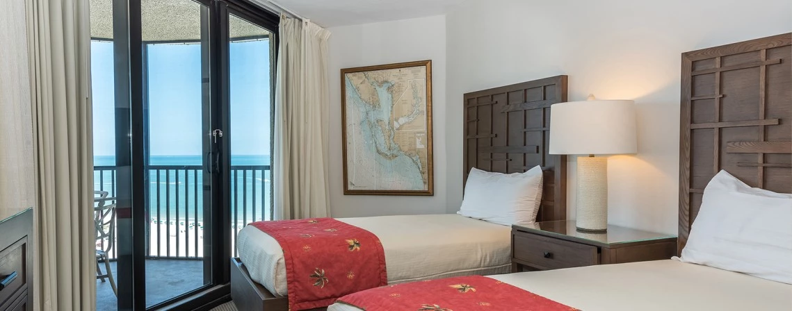 a bedroom with two beds and a glass door