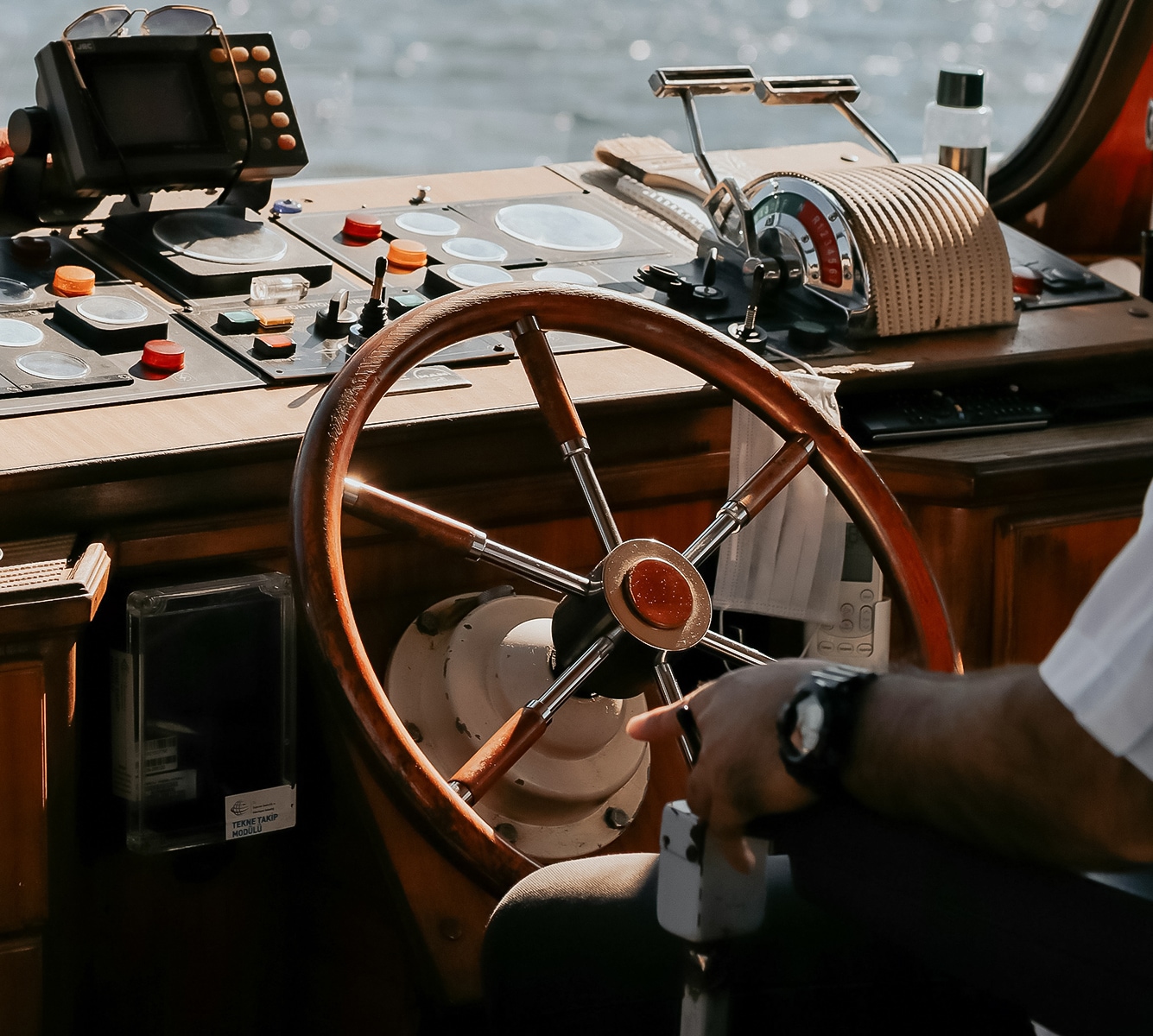 a man holding a steering wheel in a boat