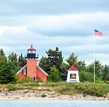 a lighthouse and a flag on a pole