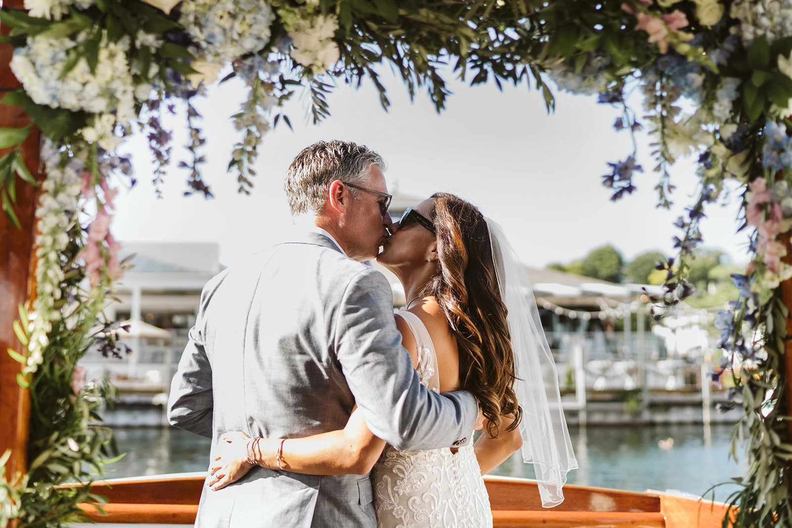 a man and woman kissing under a flower arch