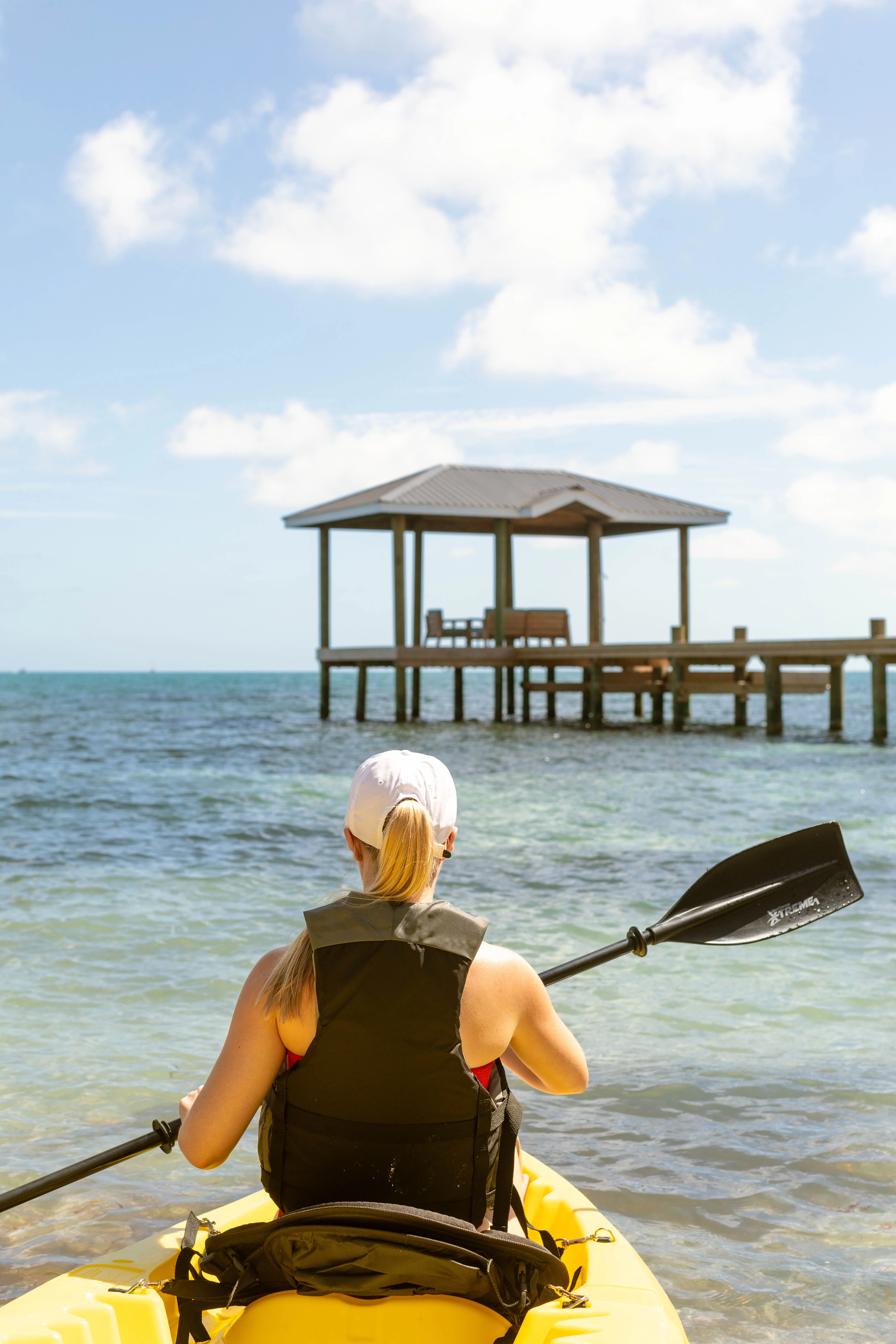 a woman sitting in the water with a paddle