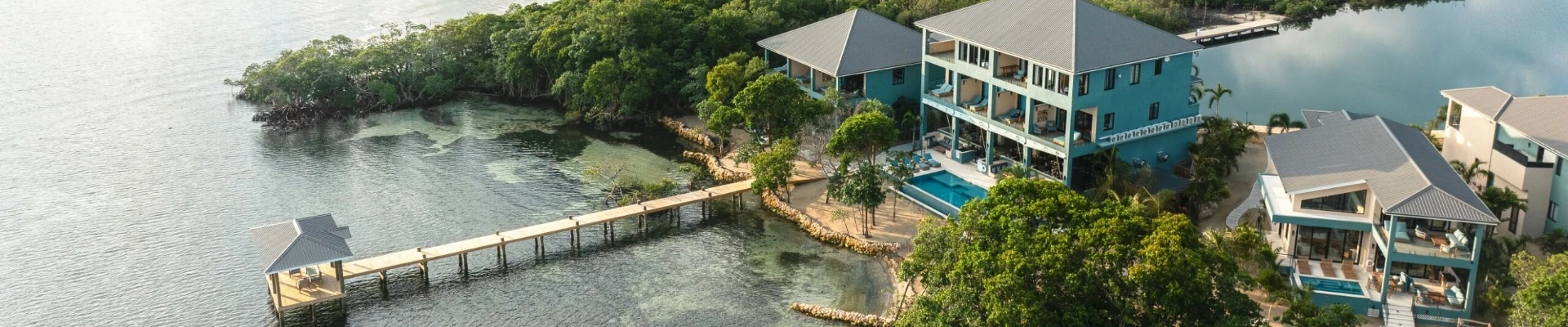 a building with a pool and a dock over water