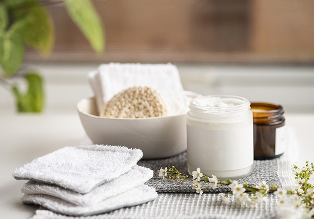 a white bowl with a white container and a white bowl with a white object next to a white towel
